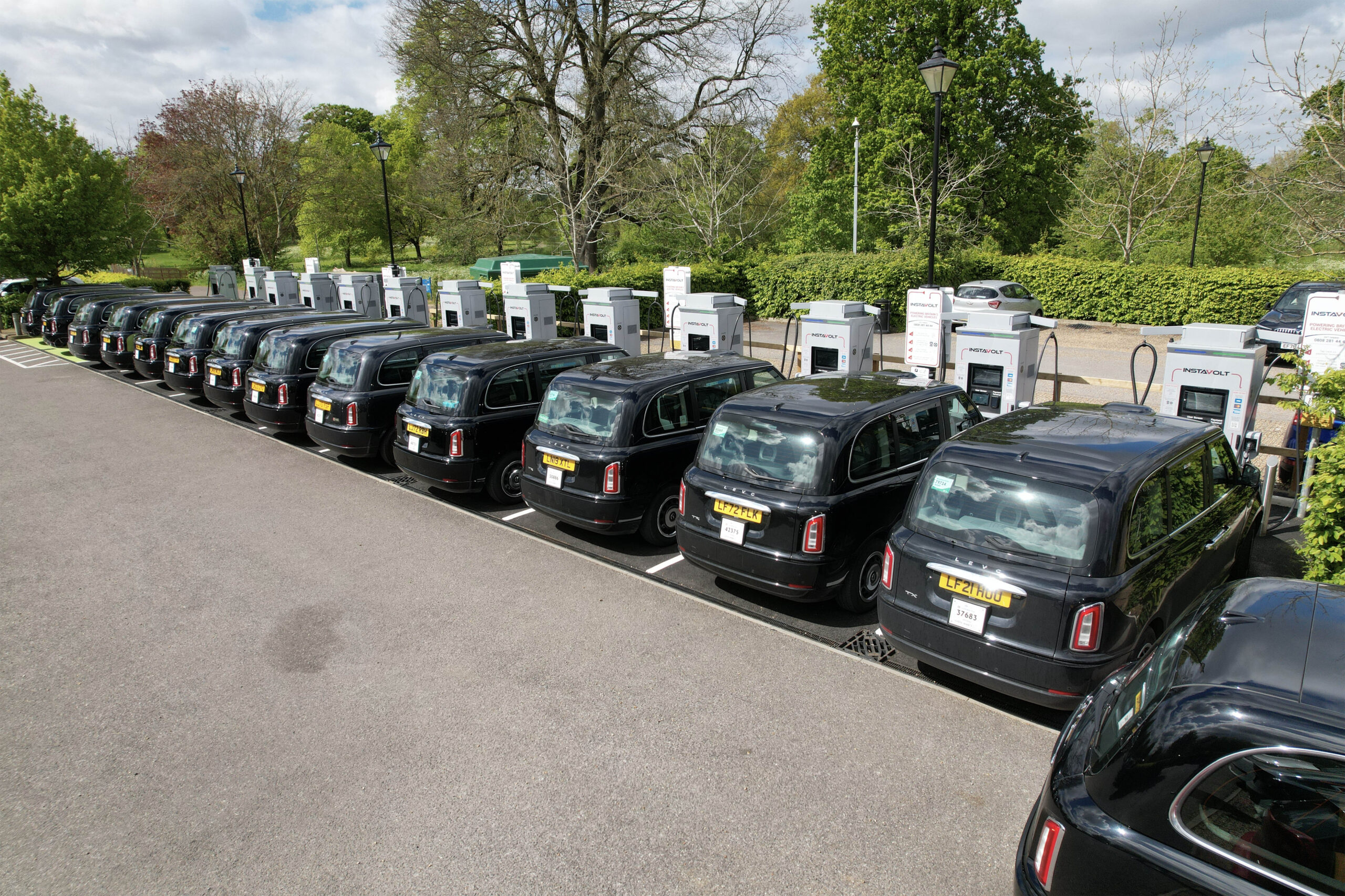 A line of electric black cabs charging at InstaVolt rapid EV chargers