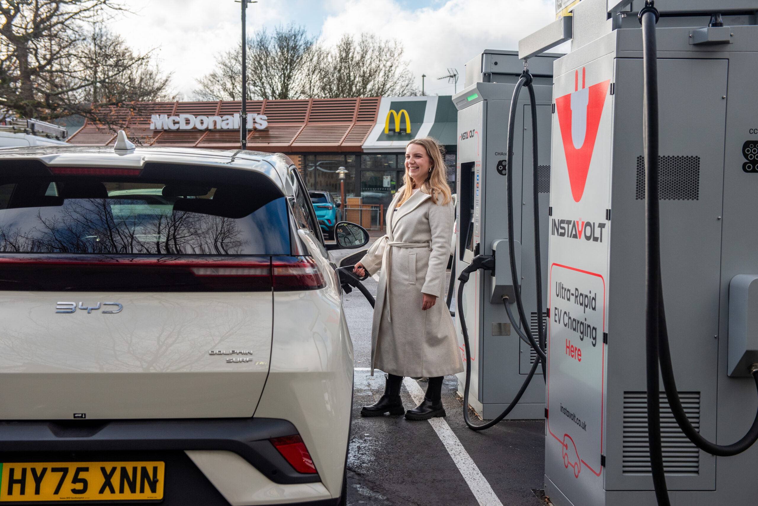 Woman charging her electric vehicle at InstaVolt ultra-rapid charger